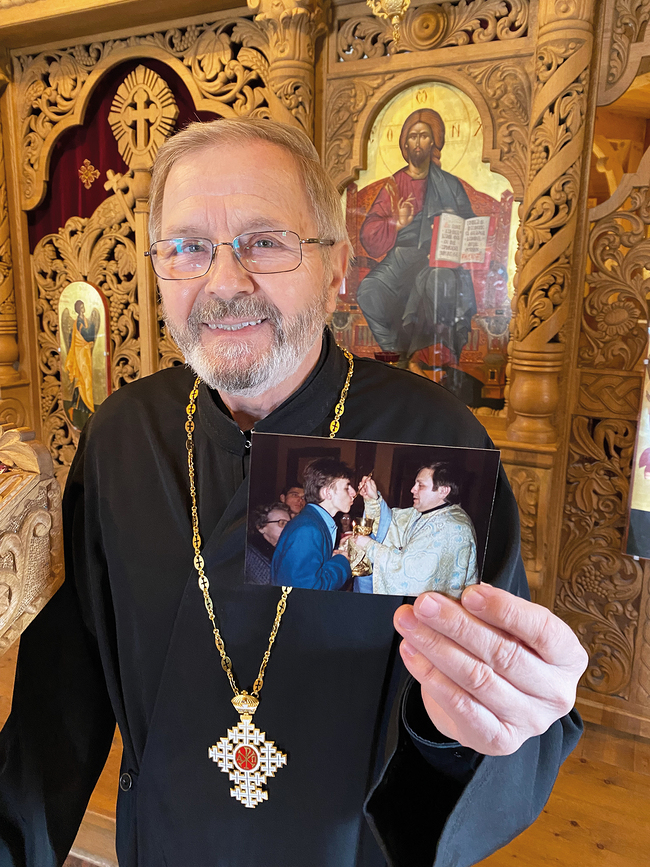 Erzpriester Dumitru Viezuianu mit einem Foto, auf dem er seinem Sohn die heilige Kommunion spendet.