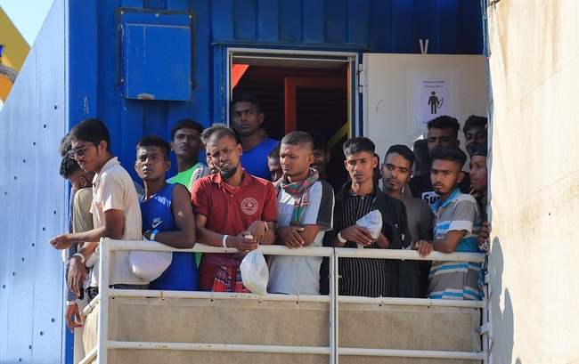 Bootsmigranten bei der Ankunft in einem Mittelmeerhafen.
