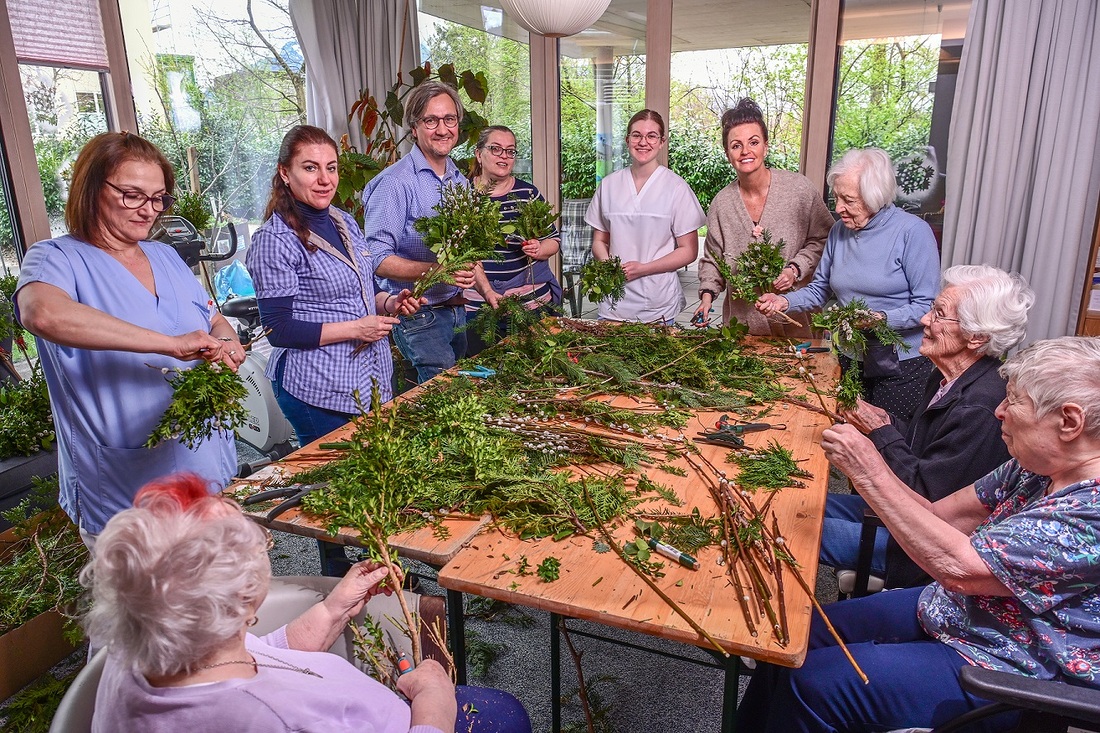 Altenseelsorger Peter Ebner beim Palmbuschenbinden mit der generationenübergreifenden Damenrunde.